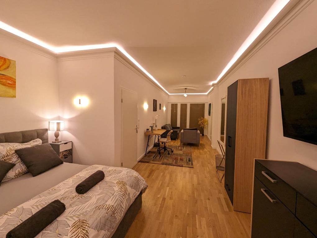 ein Schlafzimmer mit einem Bett und ein Wohnzimmer in der Unterkunft Gemütliche Zimmer im Herzen der Stadt EM-APARTMENTS DEUTSCHLAND in Bielefeld