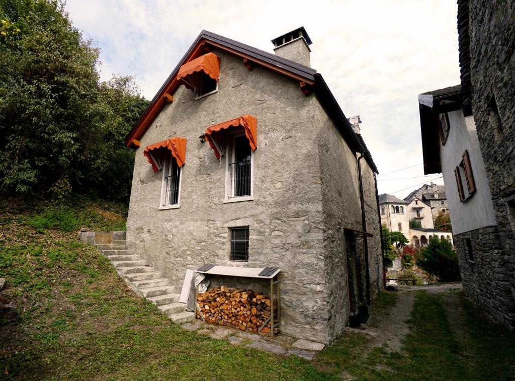 une ancienne maison en pierre avec une cheminée en face de celle-ci dans l'établissement CASA DEL CECCO, à Trontano