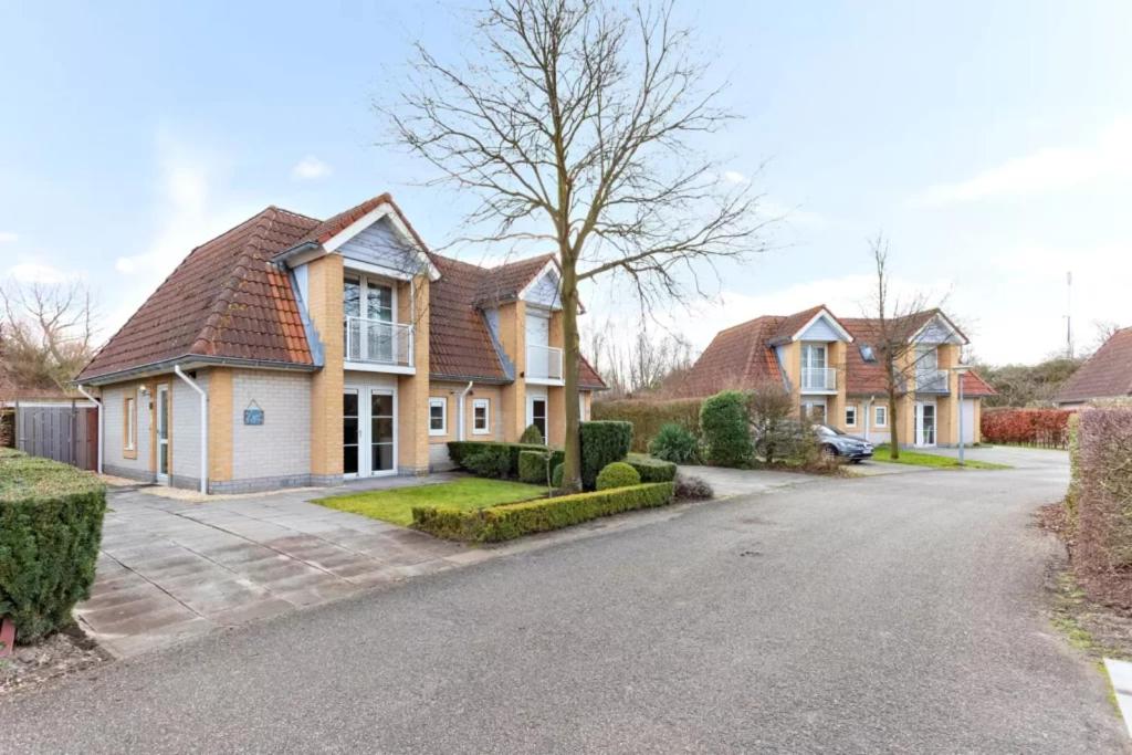 a house with a driveway in front of it at Vakantiehuis met Luxe Tuin dichtbij het strand in Kamperland