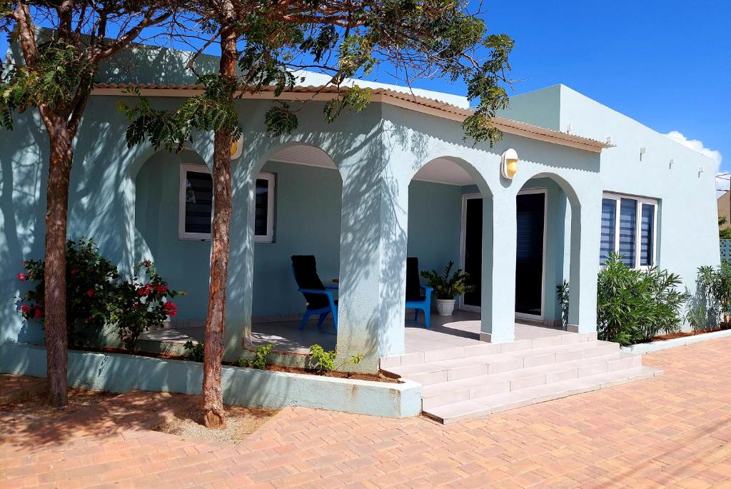 a white house with a porch and a tree at Apartment Villa Valentina - Studio 2 in Noord