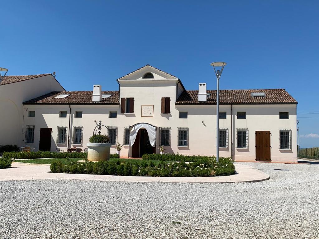 a large white house with a driveway in front of it at Possessioni Ferraresi in Melara