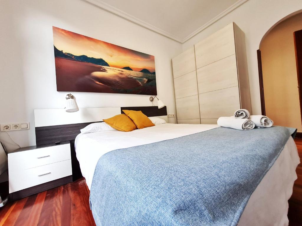 1 dormitorio con 2 camas y un cuadro en la pared en Pension Yoldi, en San Sebastián