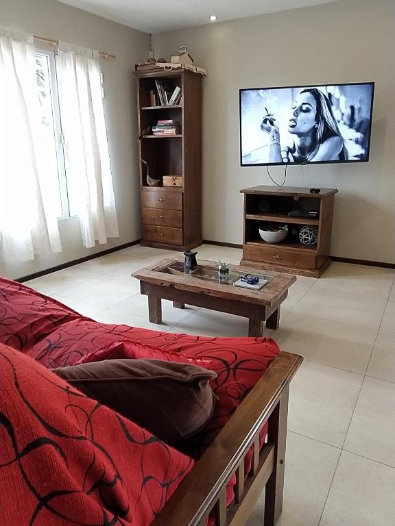 sala de estar con sofá y TV de pantalla plana en La Casa de Vero en Acantilados en Mar del Plata