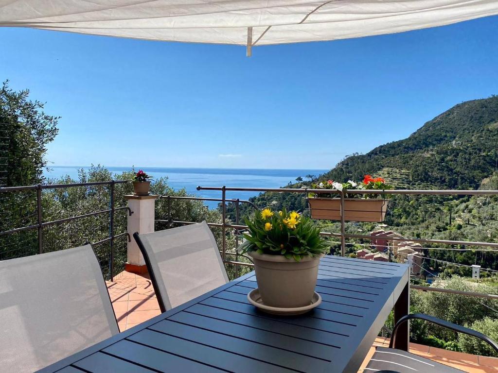 - une table bleue avec des fleurs sur le balcon dans l'établissement Sunrise apartament, à Monterosso al Mare