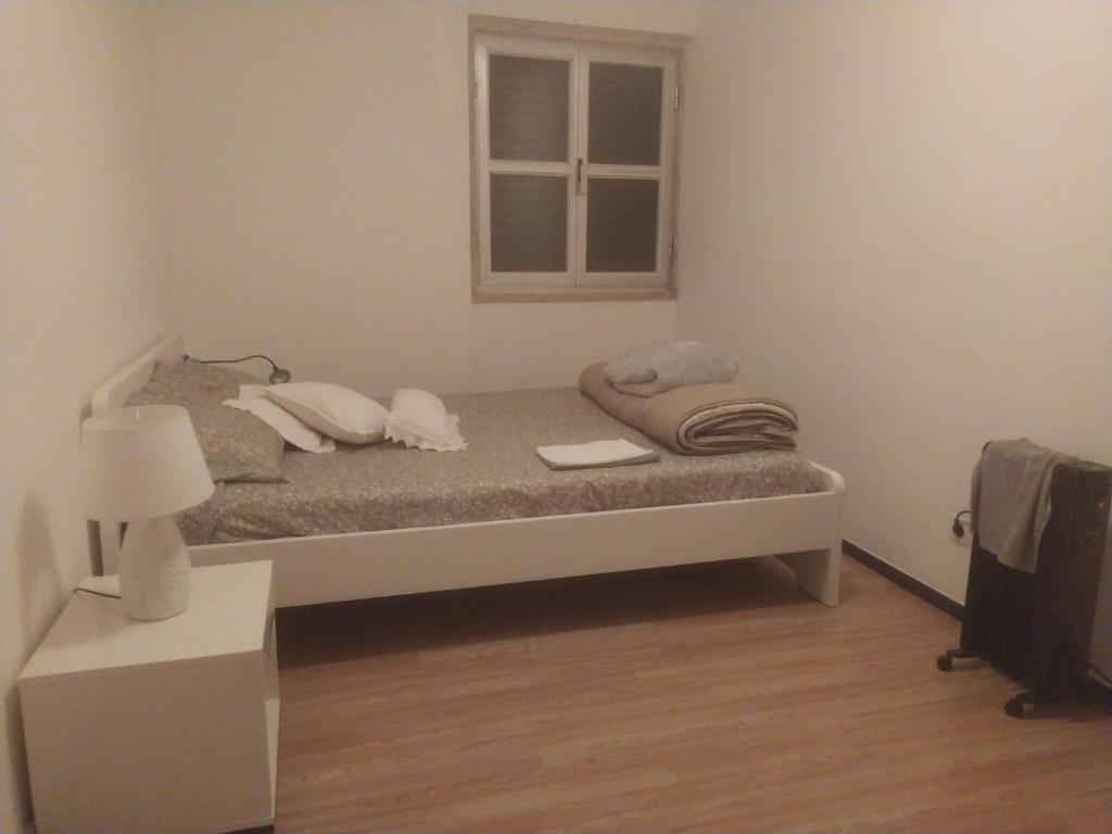 1 dormitorio con cama con almohadas y ventana en Ginjals-67, en Almargem do Bispo
