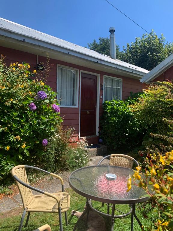 une table et des chaises devant une maison dans l'établissement Cabanas Klenner, à Puerto Varas