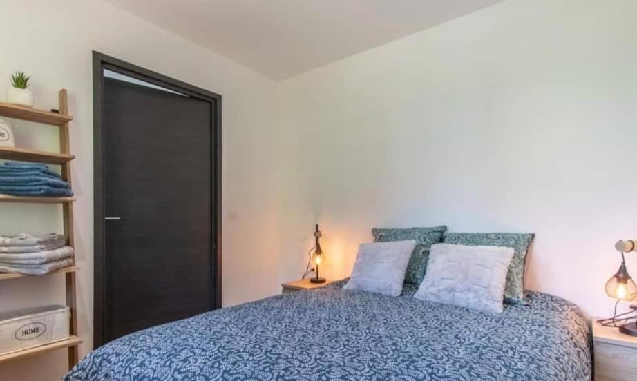 ein Schlafzimmer mit einem blauen Bett mit zwei Kissen in der Unterkunft LA BECCAZ in Montmin