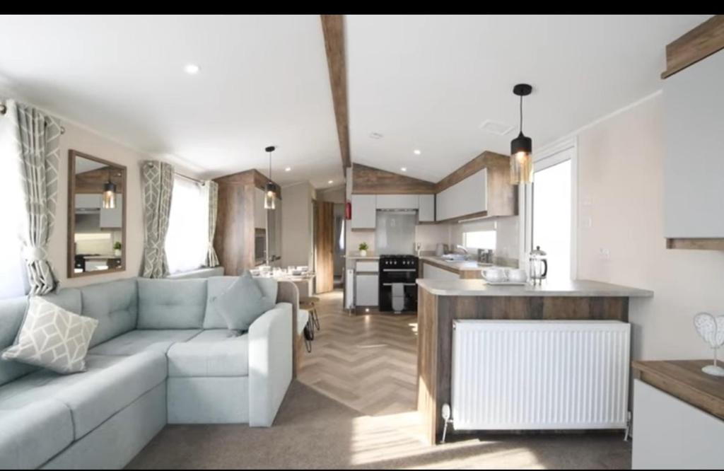 a living room with a couch and a kitchen at Q8 ocean edge caravan park in Heysham