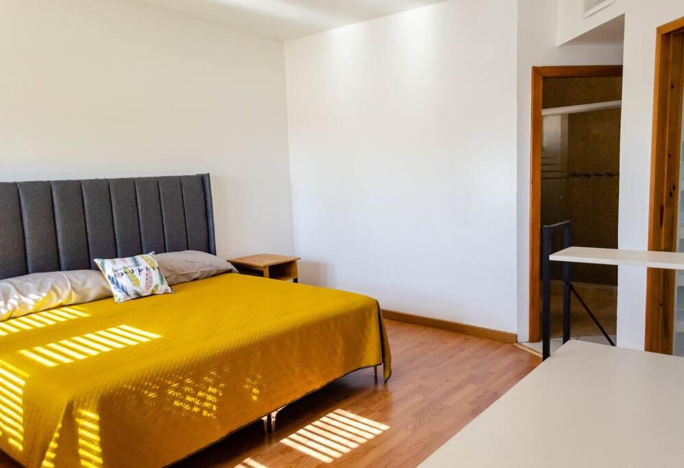 een slaapkamer met een bed met een gele deken bij Alojamiento completo 3 habitaciones (se puede facturar) in Chihuahua
