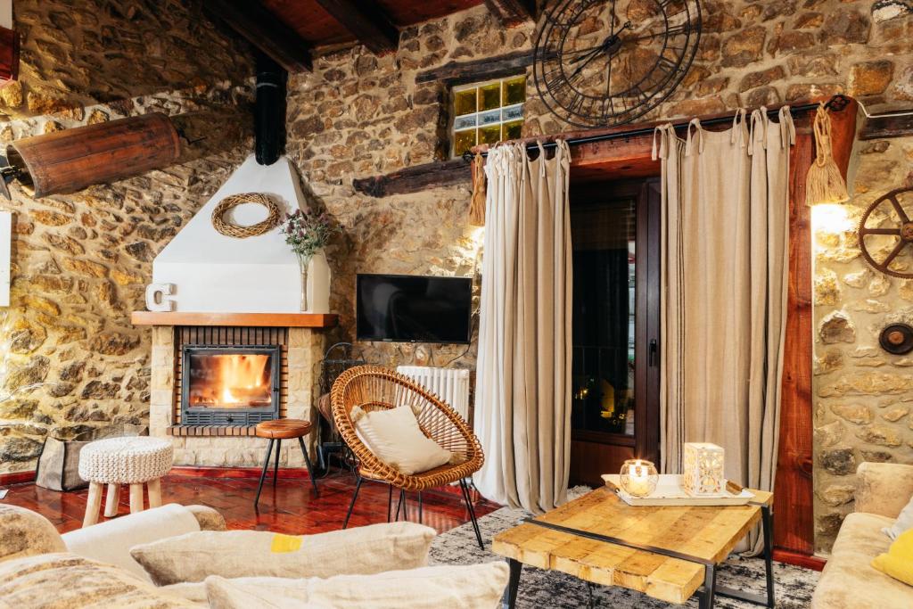 sala de estar con pared de piedra y chimenea en Casa Rural Palacio, en Linares de Mora