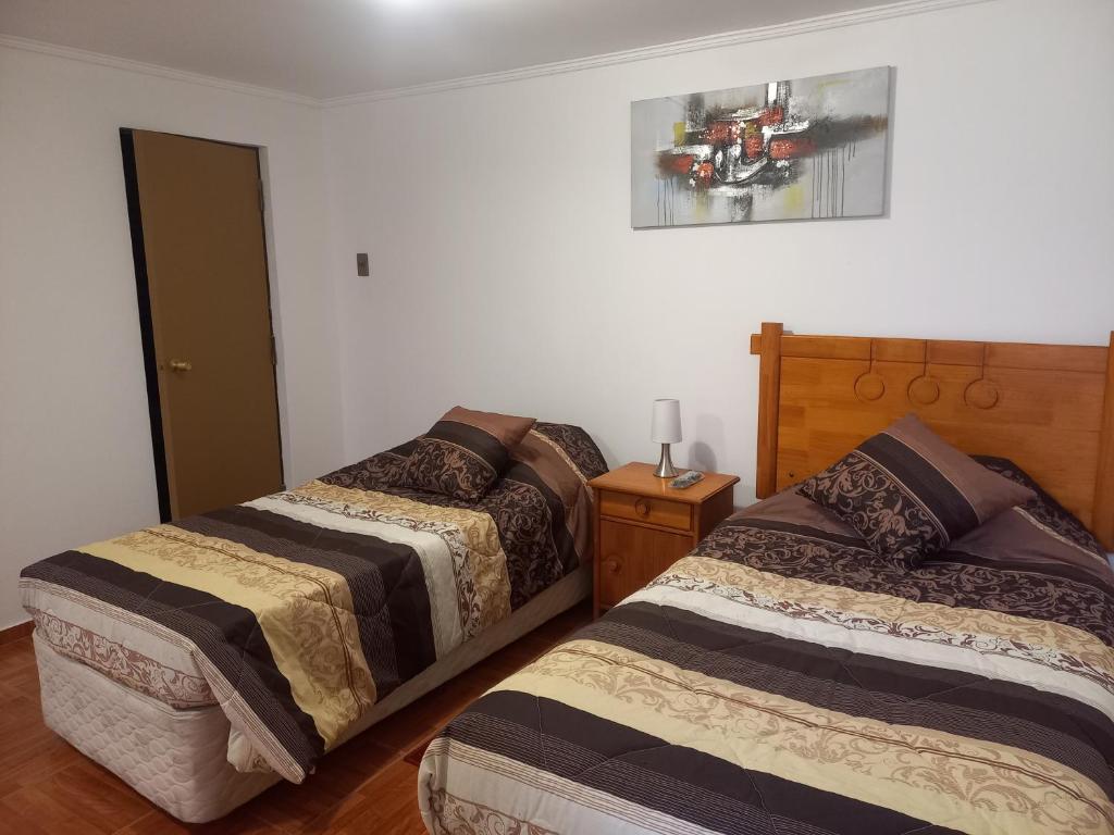 sypialnia z 2 łóżkami i zdjęciem na ścianie w obiekcie Nada w mieście Coquimbo