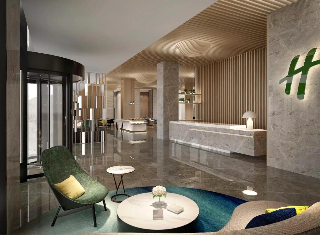 un vestíbulo con una silla verde y una mesa en Holiday Inn & Suites Suzhou Yangcheng Lake, an IHG Hotel en Suzhou
