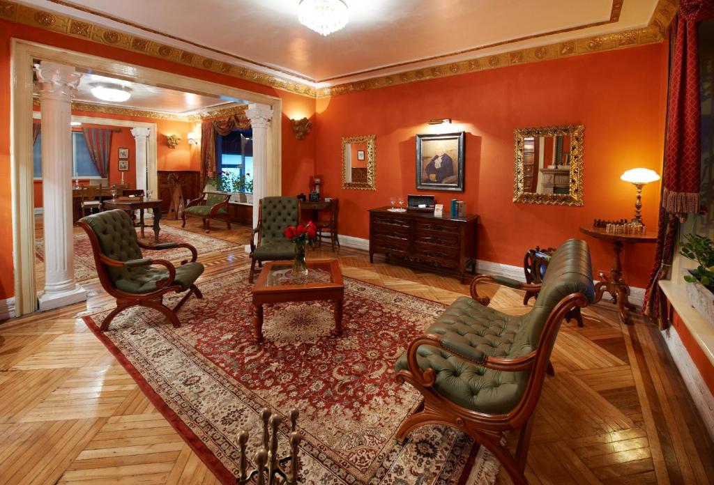 una sala de estar con paredes y sillas de color naranja y una mesa. en City Art Hotel Silberstein en Quito