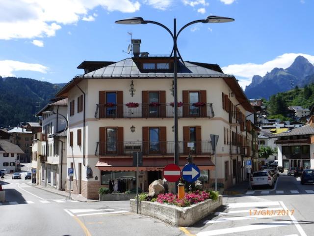 a building on the corner of a street with a street light at Auronzo Vacanze di Marina e Valter - Corte 12 in Auronzo di Cadore