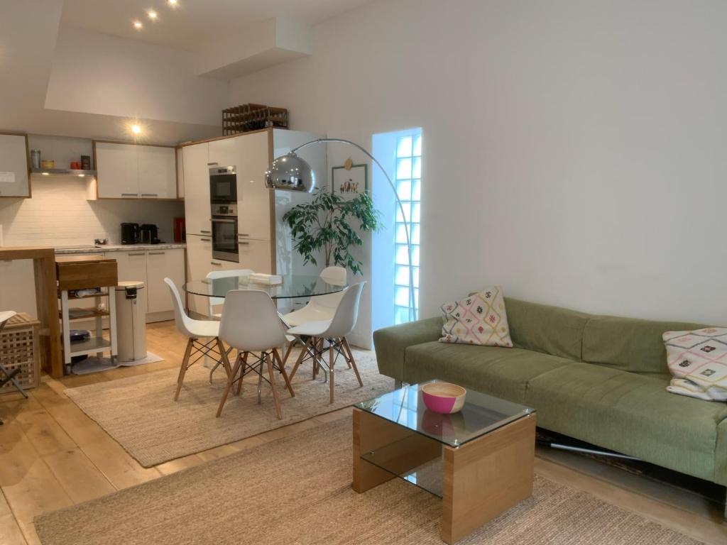 ein Wohnzimmer mit einem grünen Sofa und einem Tisch in der Unterkunft Luxury 3-Bedroom Townhouse in Hackney in London