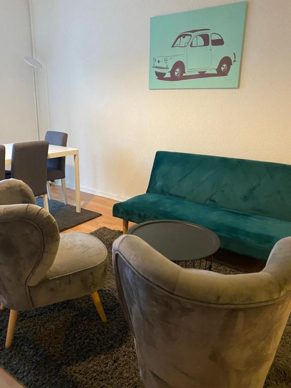 ein Wohnzimmer mit einem Sofa, Stühlen und einem Tisch in der Unterkunft Osthafen III in Berlin