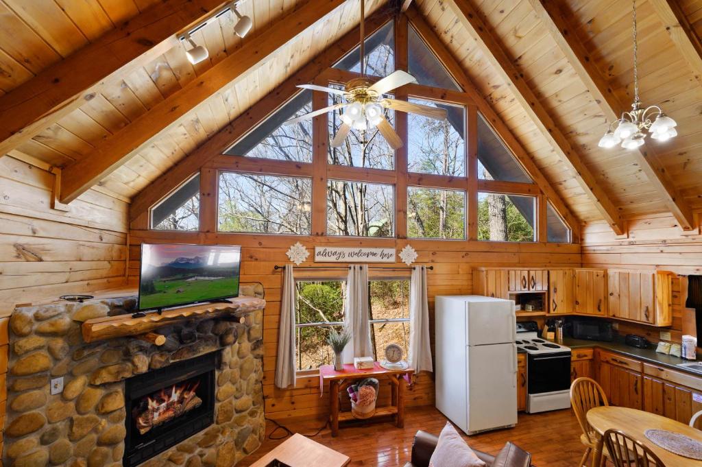 a kitchen and living room with a fireplace in a log cabin at Rustic Retreat in Sevierville