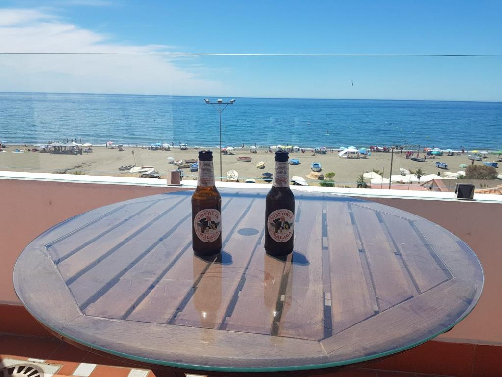 Duas garrafas de vinho numa mesa na varanda em Céntrico ático junto al mar em Rincón de la Victoria