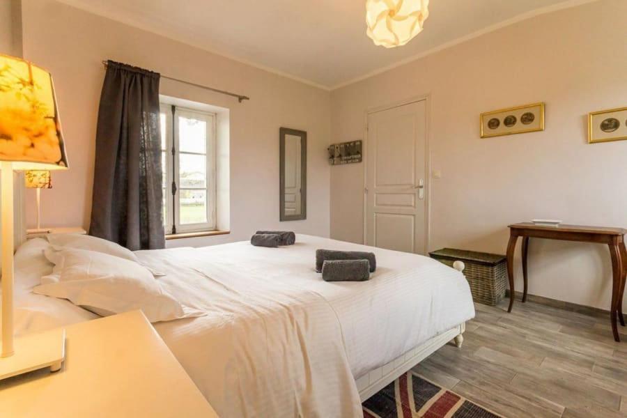 1 dormitorio con 1 cama blanca grande y 2 toallas en Gîte La Sellerie en Les Sorinières