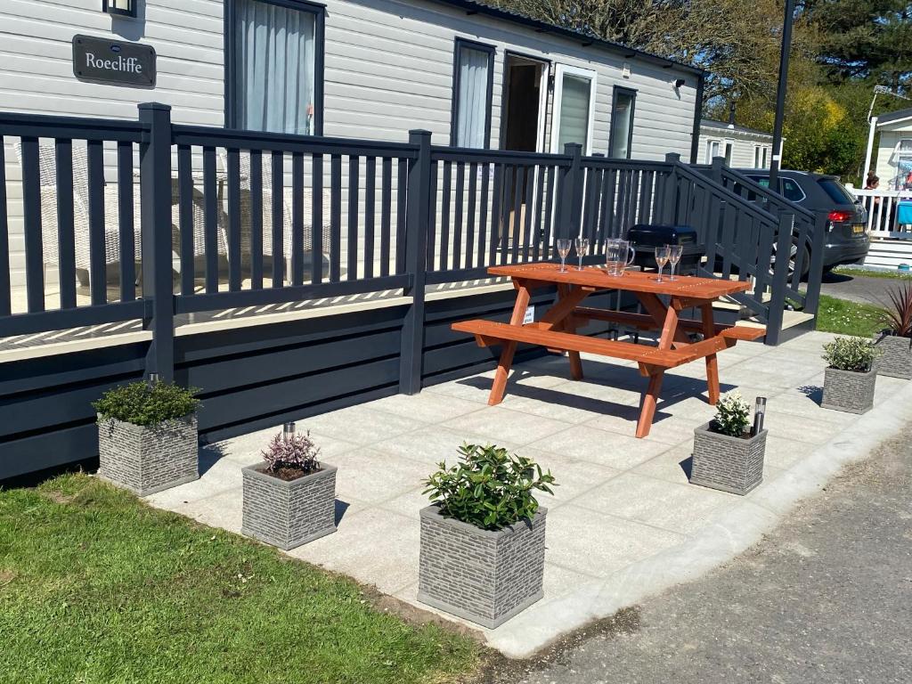 a picnic table and potted plants on a patio at The Roecliffe in Downton