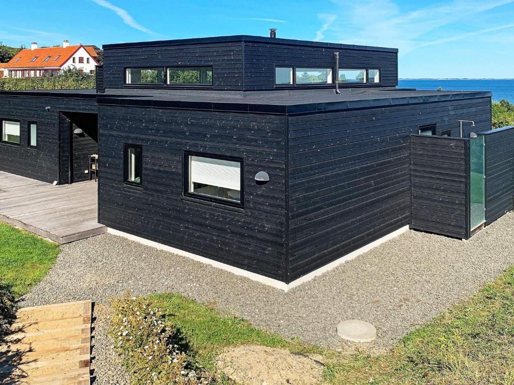 a black house with a view of the ocean at 10 person holiday home in Asn s in Asnæs