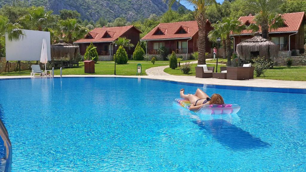a woman laying on a raft in a swimming pool at Club Sun Village Hotel in Adrasan