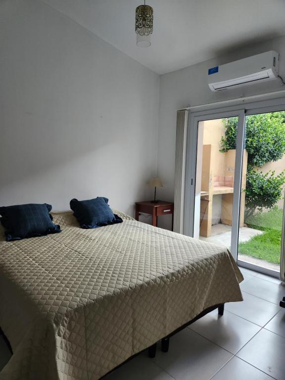 1 dormitorio con 1 cama y puerta corredera de cristal en Casa Tres Cerritos en Salta