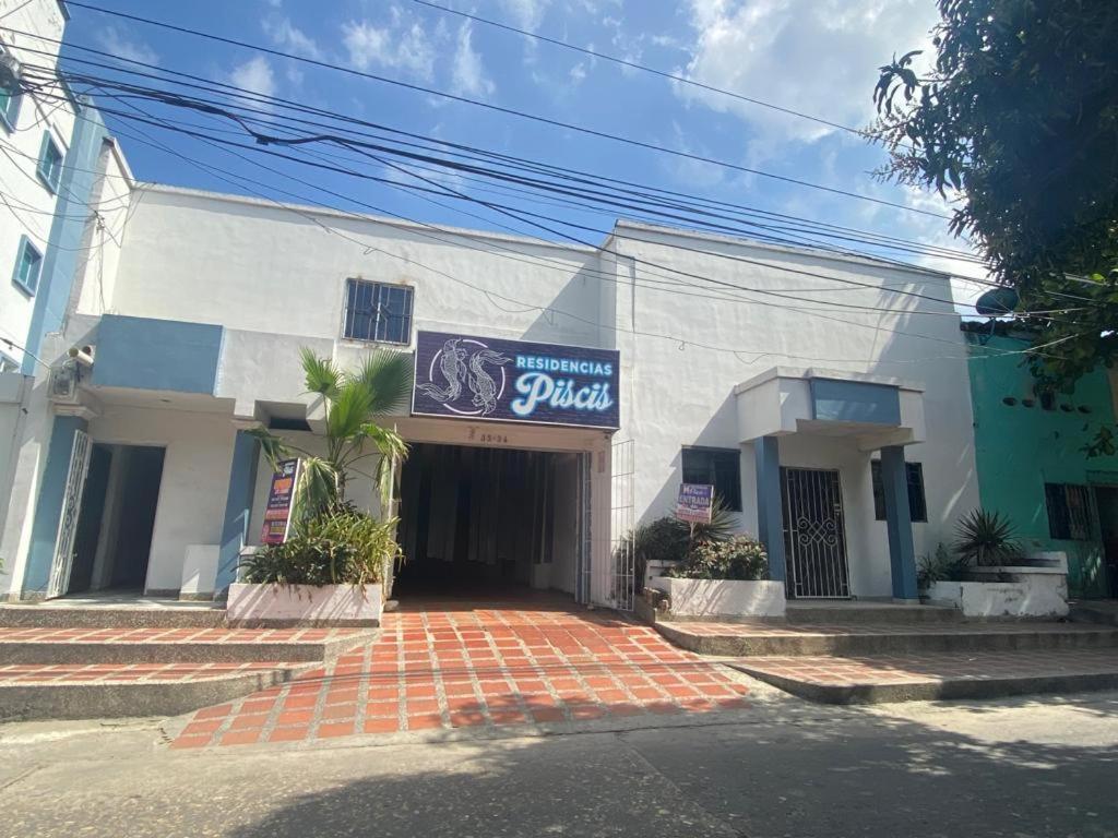 a white building with a sign on the front of it at Residencias Piscis in Barranquilla