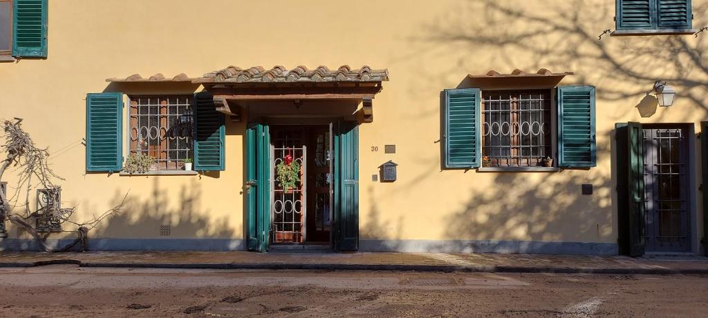 un edificio con persianas azules y una puerta en Poggio alla Scaglia, en Florencia