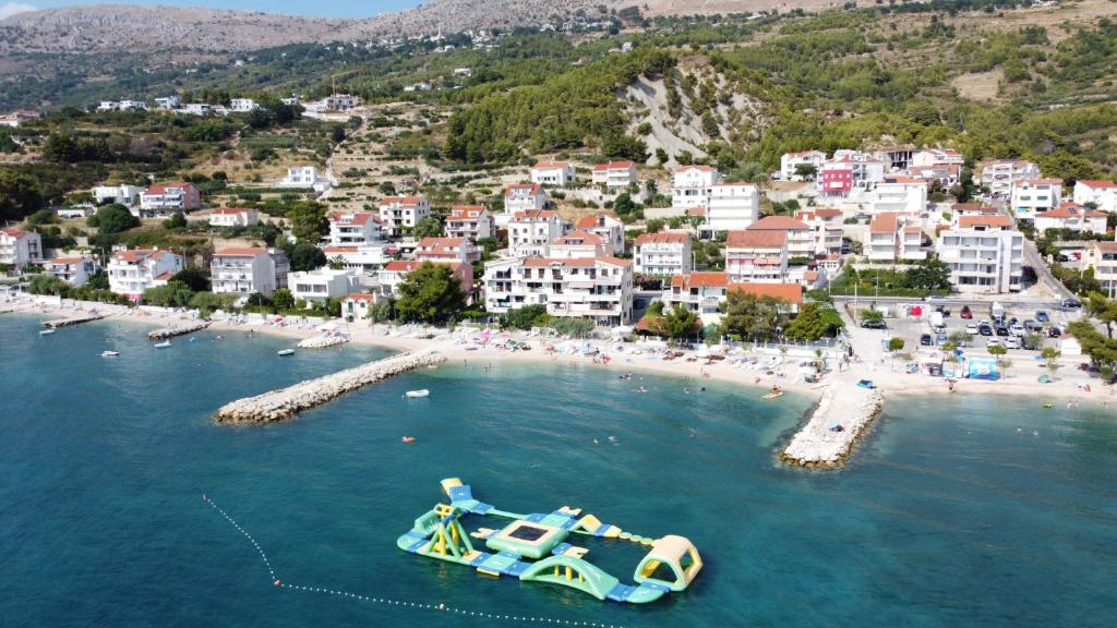 un barco en el agua cerca de una playa en Apartments Ivica, en Podstrana