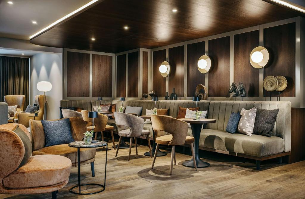 a restaurant with couches and tables and chairs at Grand Tirolia Kitzbühel - Member of Hommage Luxury Hotels Collection in Kitzbühel