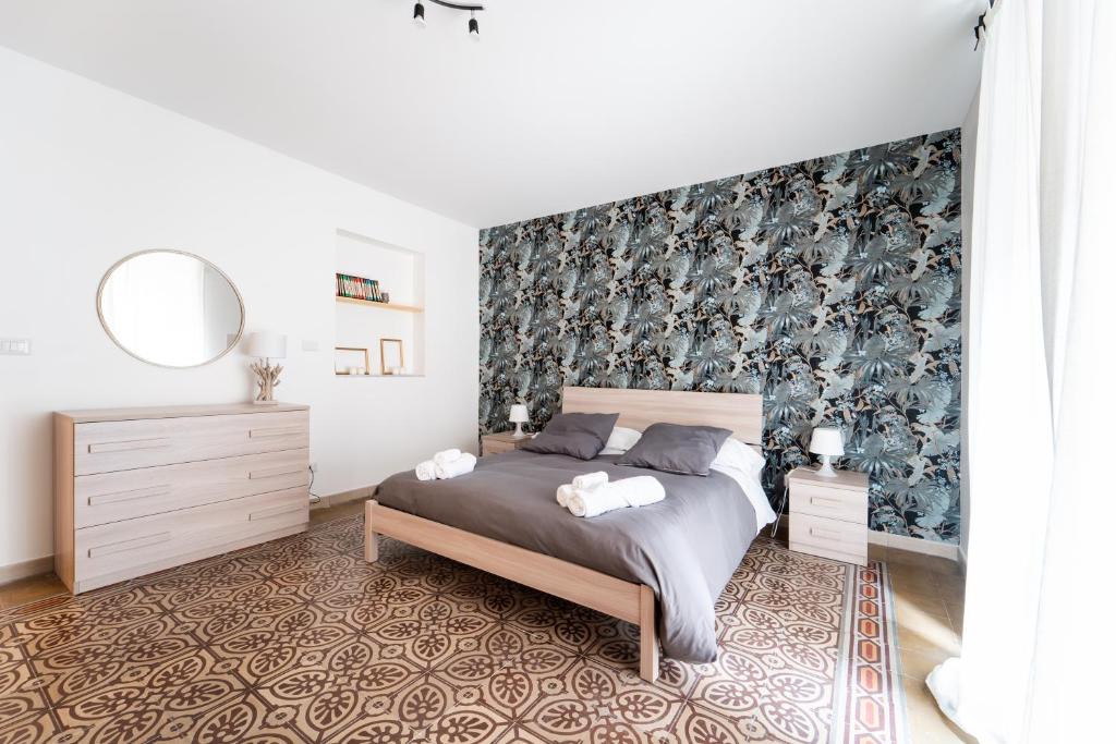 una camera da letto con un letto e carta da parati floreale di Historic Center Apartment - Catania Stays a Catania