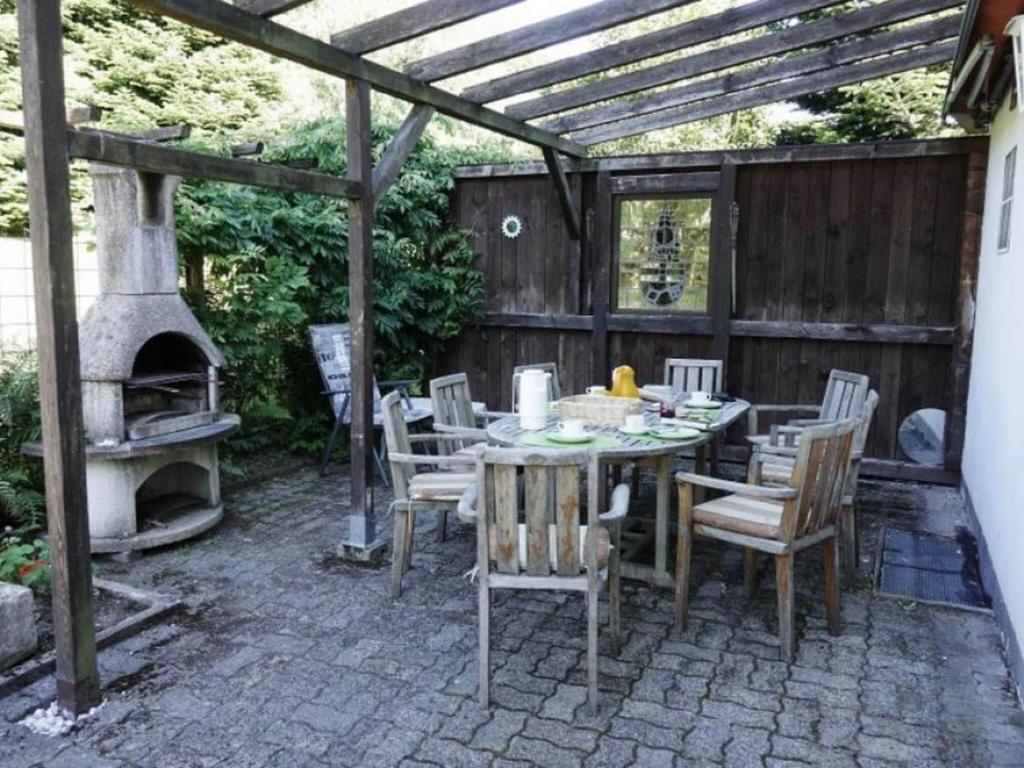 een patio met een tafel en een buitenoven bij Cosy holiday home in Brilon with garden and barbecue in Brilon