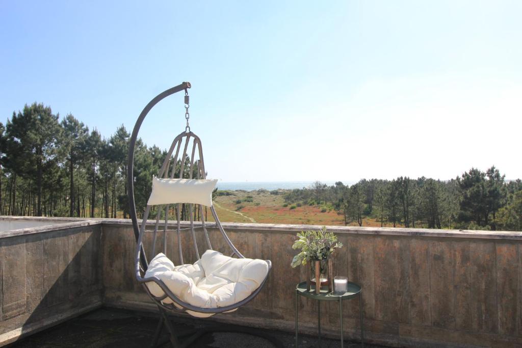 una silla mecedora en un balcón con vistas en Ocean House - First Line of Cabedelo Beach, en Viana do Castelo