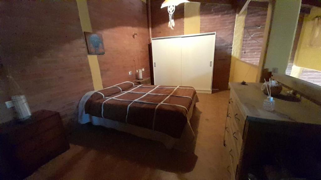 Un dormitorio con una cama y un armario. en Cabañas Akasha en San Rafael