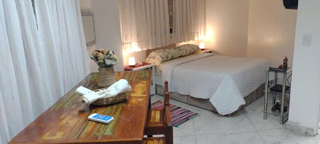 1 dormitorio con 1 cama y 1 mesa con flores en APARTAMENTO OCHAVA Reseva por mas noches y paga menos en Buenos Aires