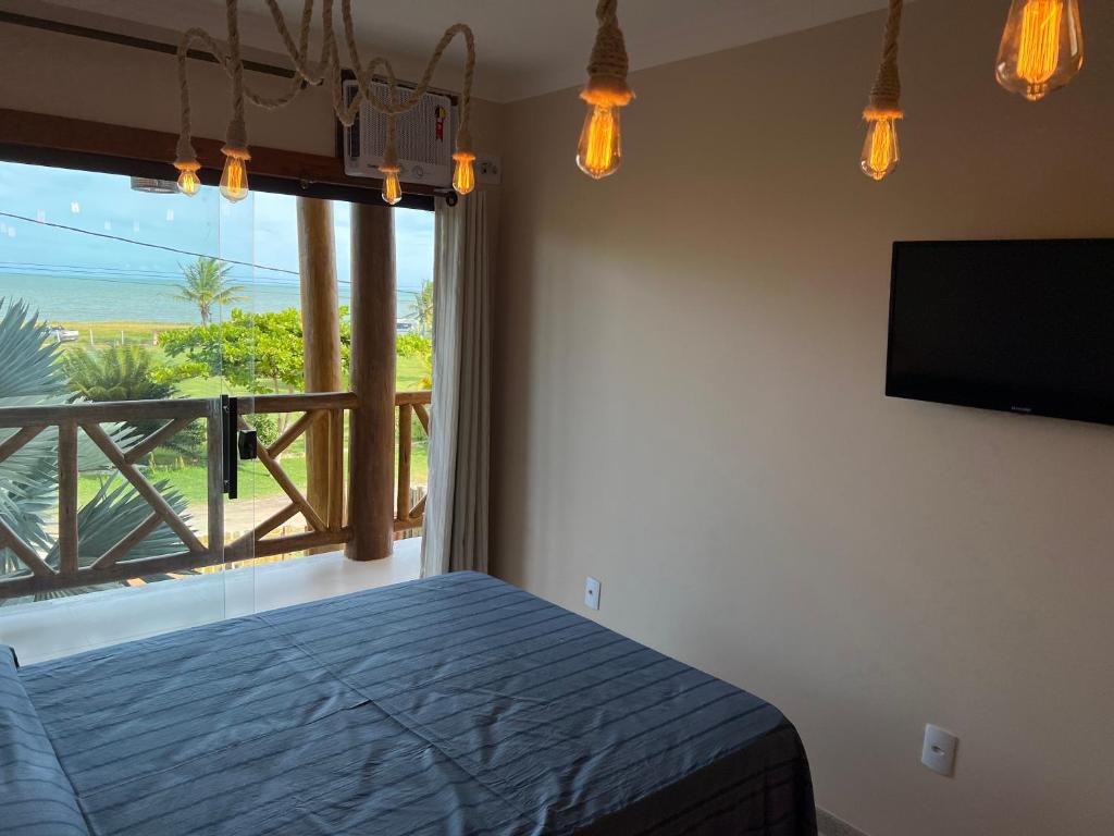 um quarto com uma cama e vista para o oceano em Recanto Bela Vista II em Costa Dourada