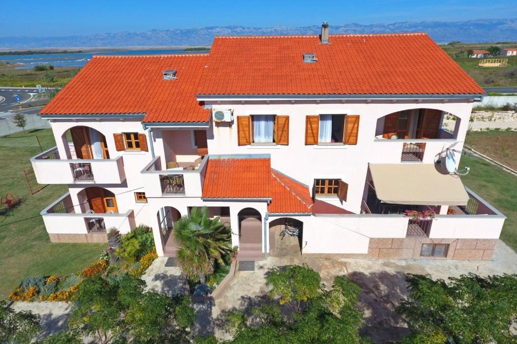 widok z powietrza na dom z pomarańczowym dachem w obiekcie Holiday apartment in Privlaka with sea view, balcony, air conditioning, WiFi 3598-5 w mieście Privlaka