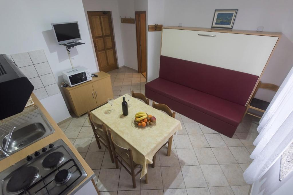 salon ze stołem i czerwoną kanapą w obiekcie Holiday apartment in Privlaka with sea view, balcony, air conditioning, WiFi 3598-5 w mieście Privlaka
