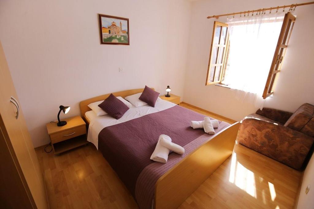 sypialnia z łóżkiem z dwoma białymi butami w obiekcie Holiday apartment in Privlaka with sea view, balcony, air conditioning, WiFi 3598-5 w mieście Privlaka
