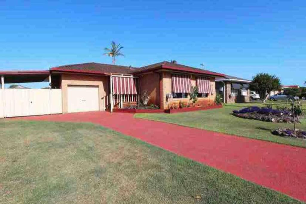 a house with a red driveway in a yard at Harrington Getaway in Harrington