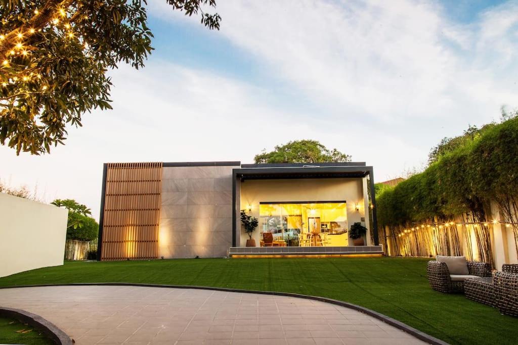 uma casa moderna com um relvado verde em Small, house with golf course view and fresh air 