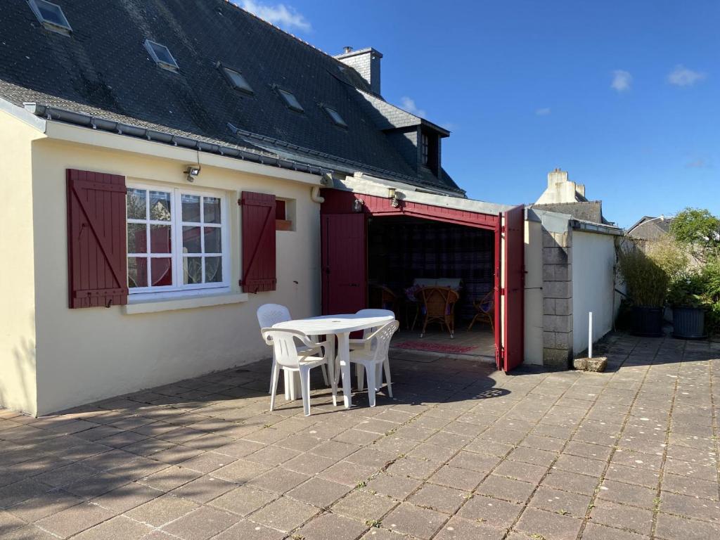 a patio with a table and chairs outside of a house at Appartement Erdeven, 3 pièces, 4 personnes - FR-1-397-47 in Erdeven