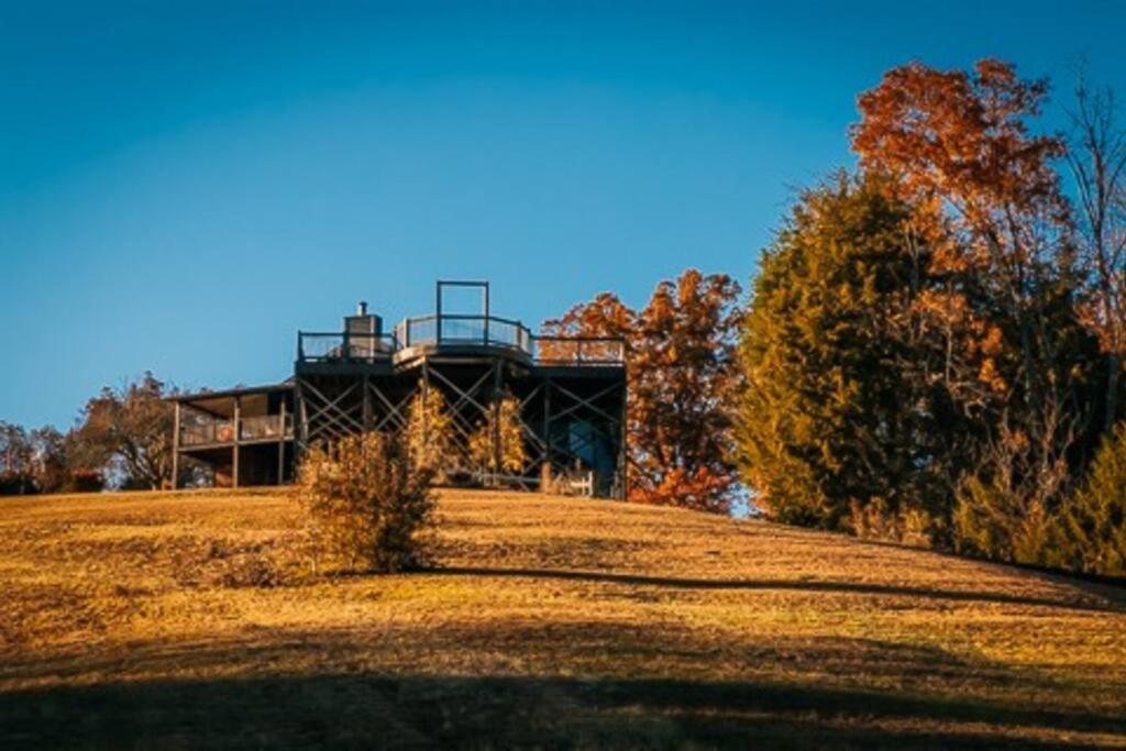a house sitting on top of a grass field at Bells With a View in Sevierville