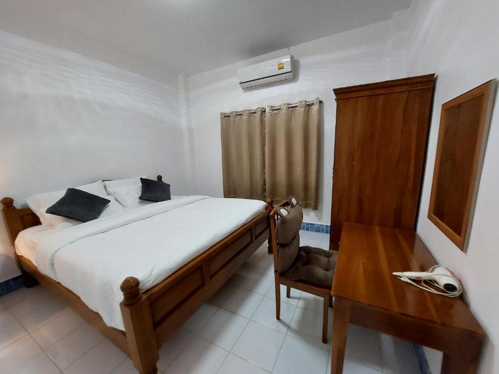 1 dormitorio con cama, mesa de madera y escritorio en U53/37 en Koh Samui