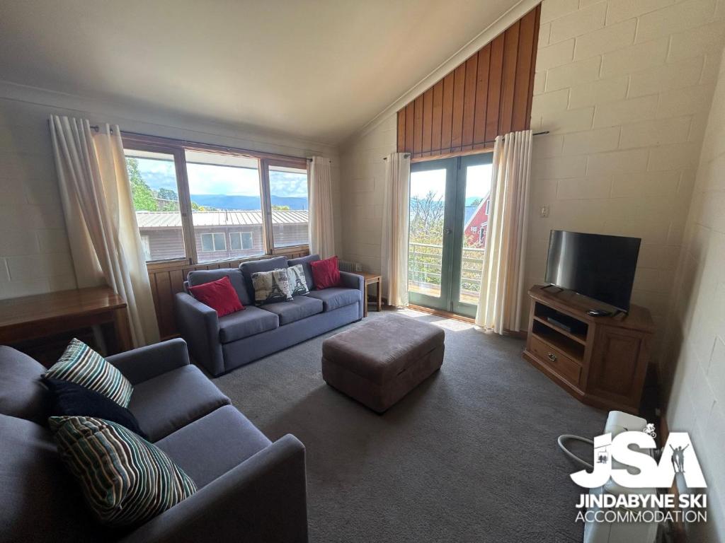 a living room with two couches and a tv at Moonbah 2 in Jindabyne