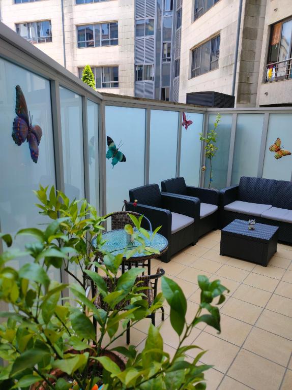 a balcony with a table and couches on a building at Apartamento Pontevedra centro HOMYHOME II in Pontevedra