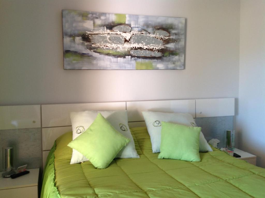 トレ・パチェコにあるLuxury appartment on golf resortのベッドルーム1室(緑のシーツと枕が備わるベッド1台付)