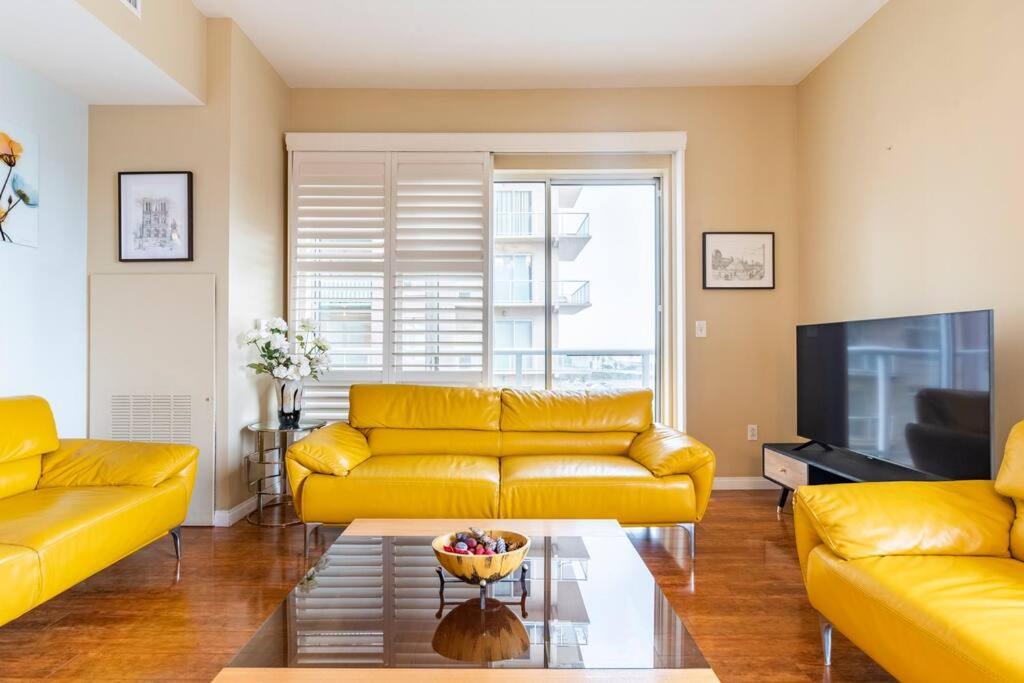 a living room with a yellow couch and a television at A Corner Unit with OCEAN VIEWS from EVERY ROOM in Long Beach