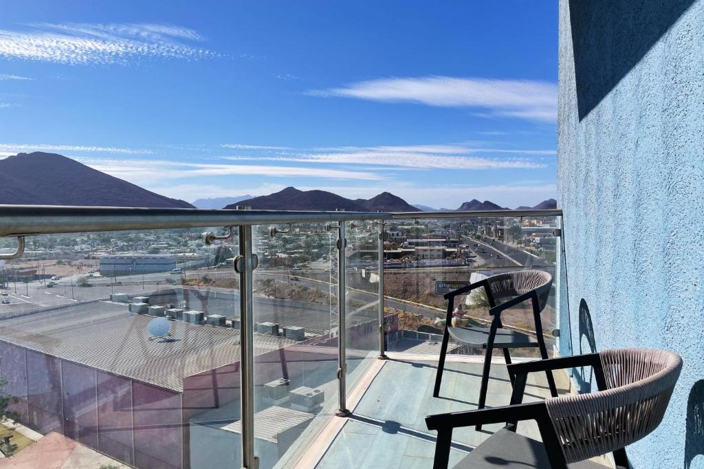 uma varanda com 2 cadeiras e vista para a cidade em Holiday Inn Express Guaymas, an IHG Hotel em Guaymas